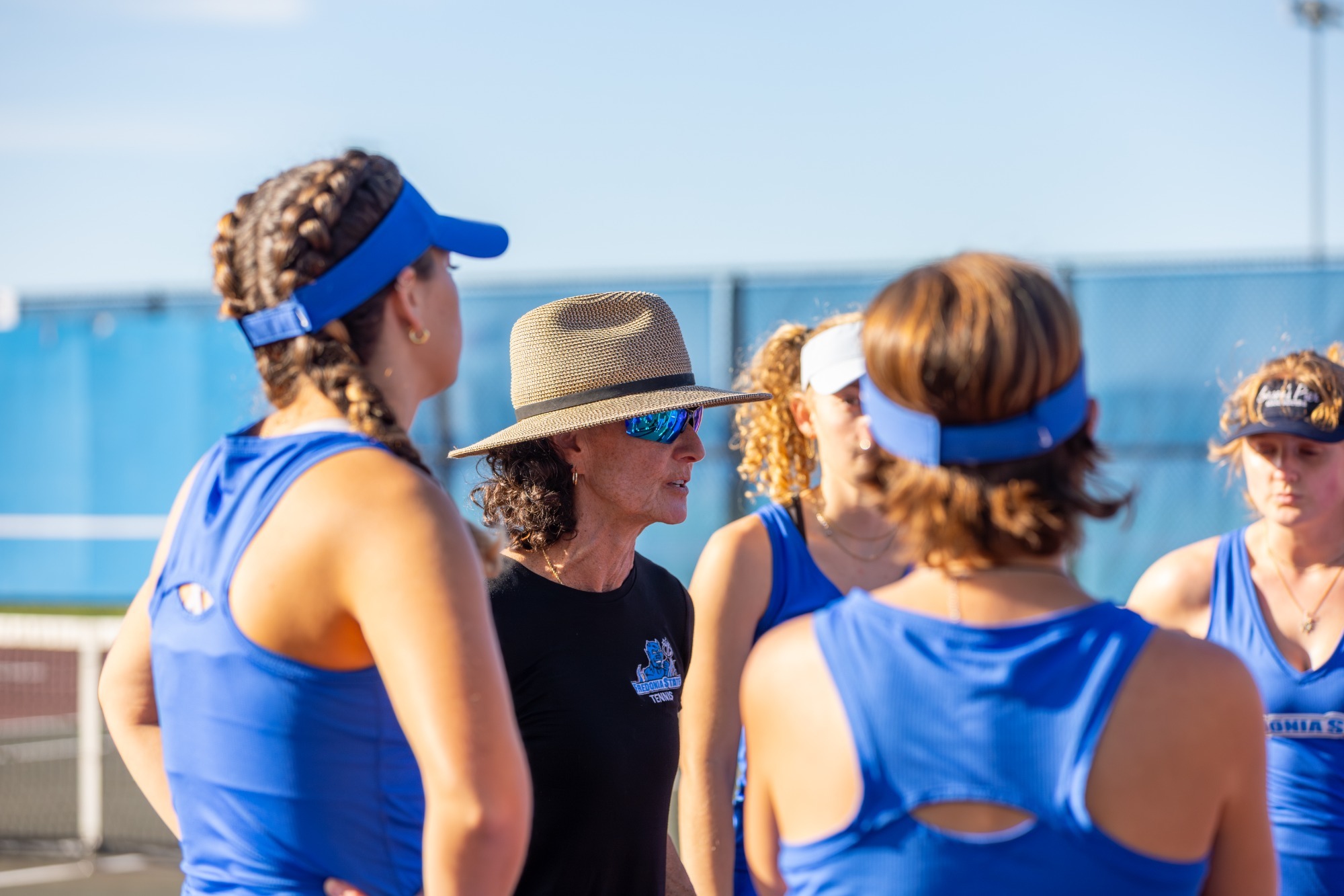Coach Jane Gens speaks with the Fredonia State tennis team