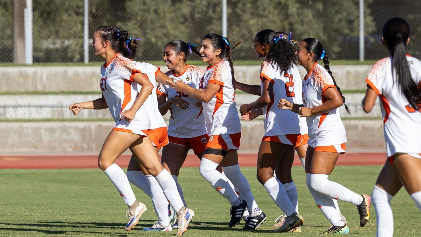 women's soccer celebrating goal on ramirez field