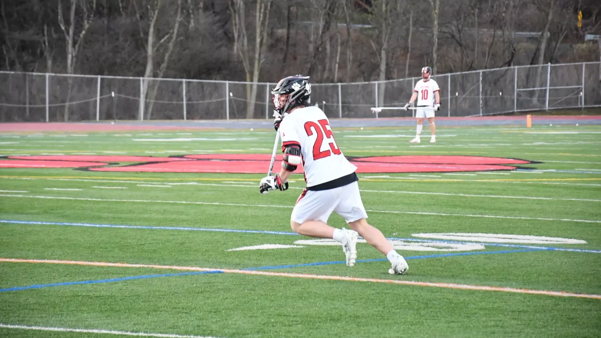 Frostburg Men's lacrosse player, number 25, Henry Sykes, cradling the ball.