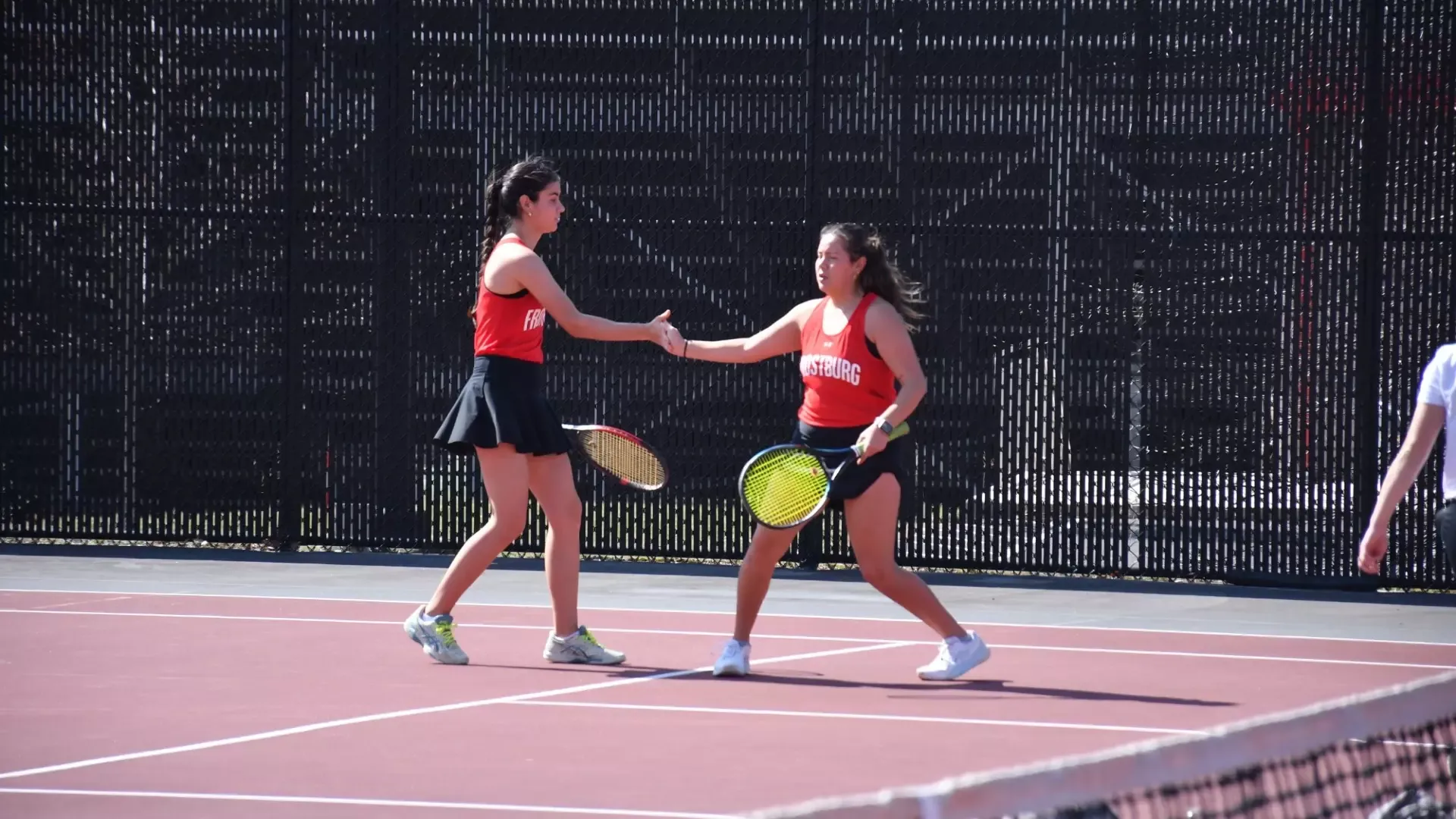 Frostburg Women's Tennis players, Patricia Castejon and Ximena Ku high five each other in doubles.