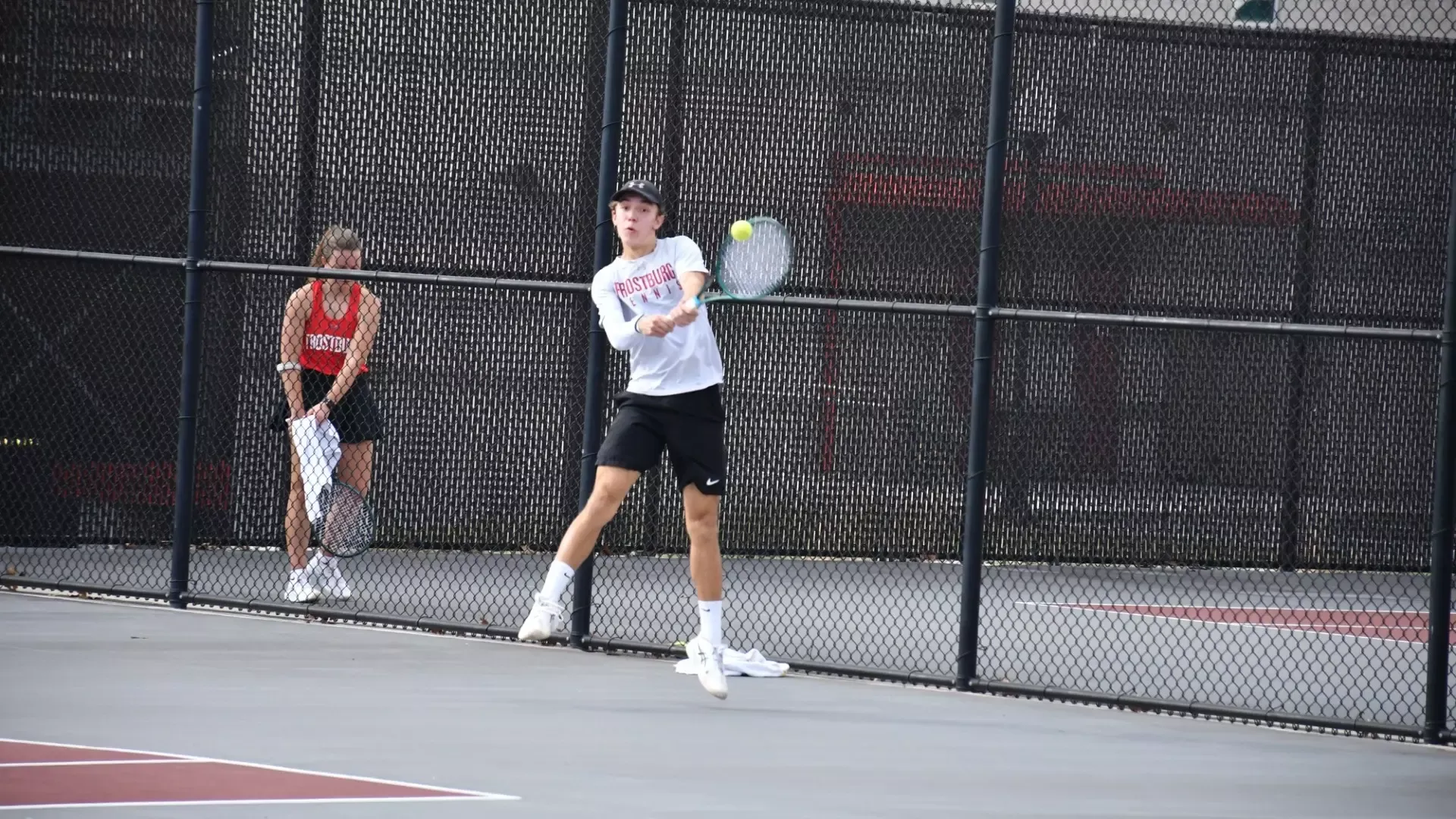 Frostbrug Men's tennis player, Tiago Iser, volleys ball back with backhand. 