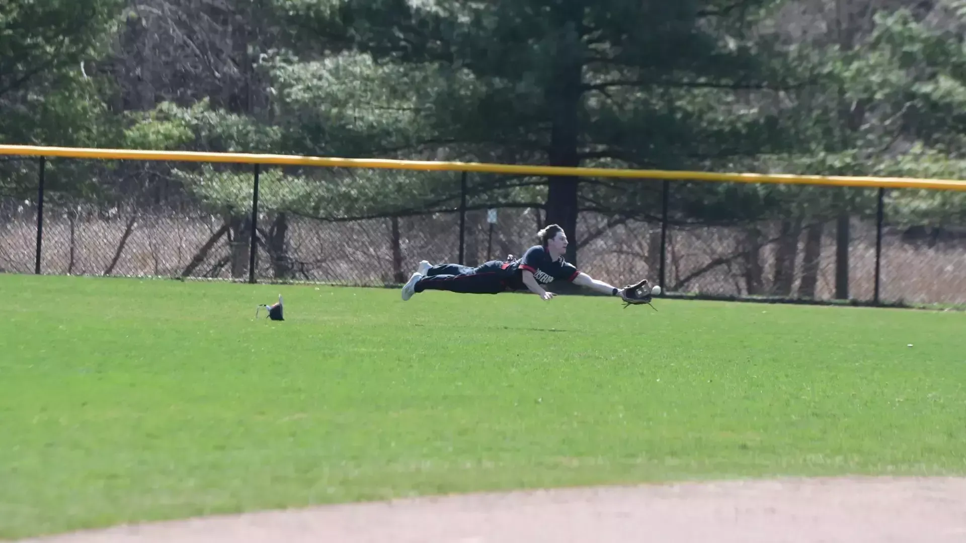 Frostburg Baseball player, number 22, Tanner Cunningham, diving to catch a ball in the outfield.
