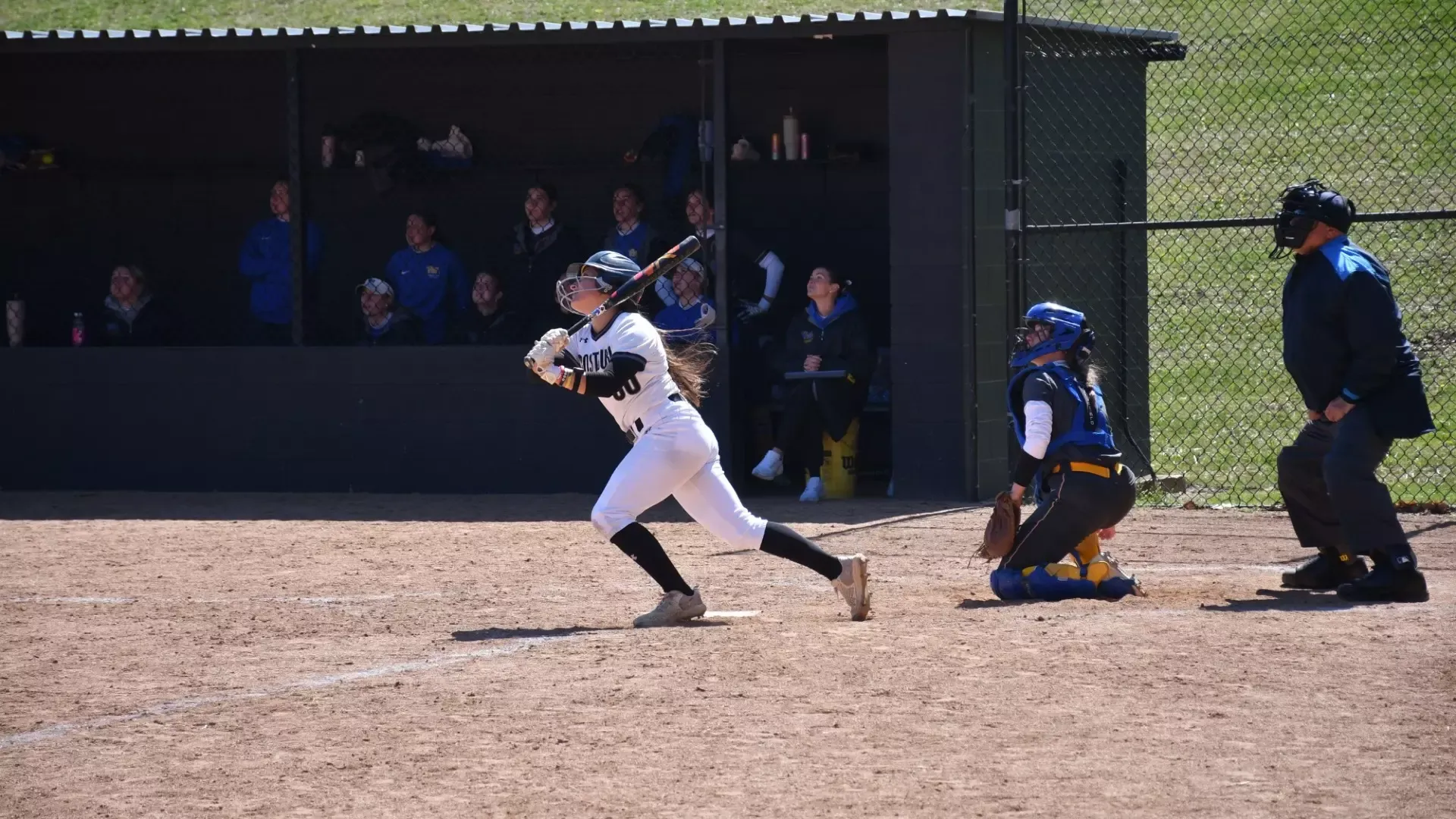 Frostburg Softball player, number 30, Arden Miller, swinging bat and taking off to run at home plate versus Pitt-Johnstown.
