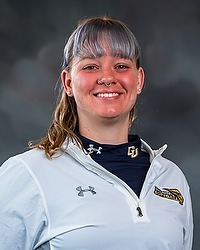 Gallaudet softball 2023 headshot Freya Nola. The coach is wearing a white pullover with a GU Bison Logo on it. The coach is photographed with a gray background in the back.