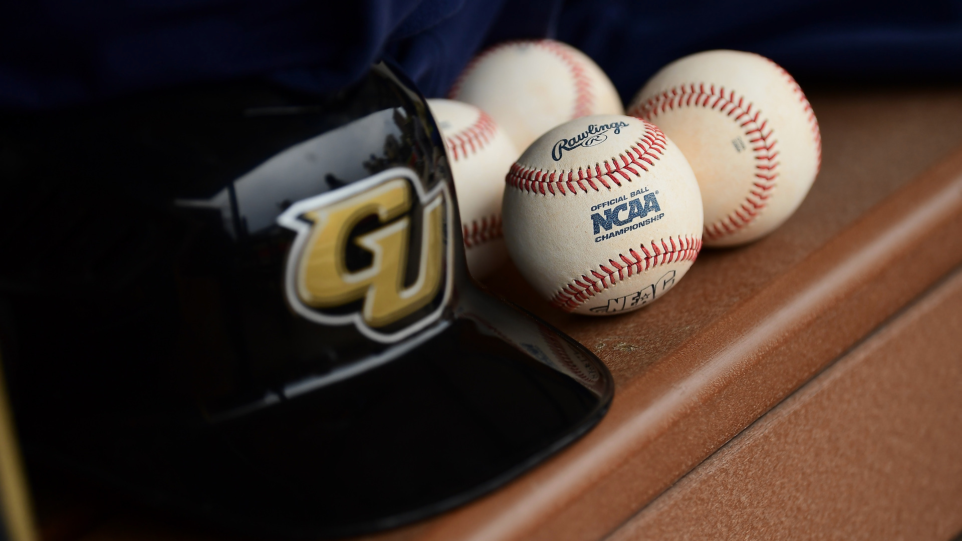 Baseball helmet and baseballs on bench