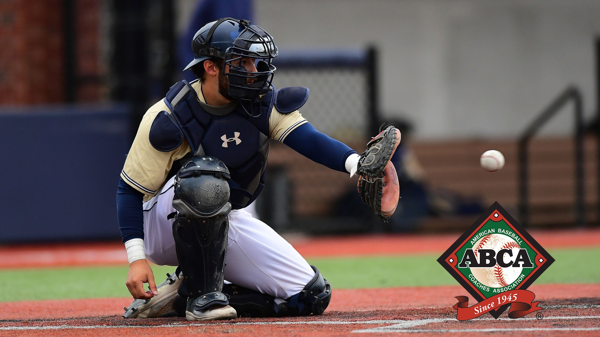GU catcher Salvador Diaz - ABCA logo - catches a baseball during a 2023 home game. An ABCA logo is in the lower righthand corner.