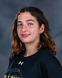 2024 WVB Headshot - Gianna Wheeler - Women's volleyball team manager looks towards the camera for a headshot. The manager is wearing a black Bison shirt. There is a gray backdrop behind the coach.