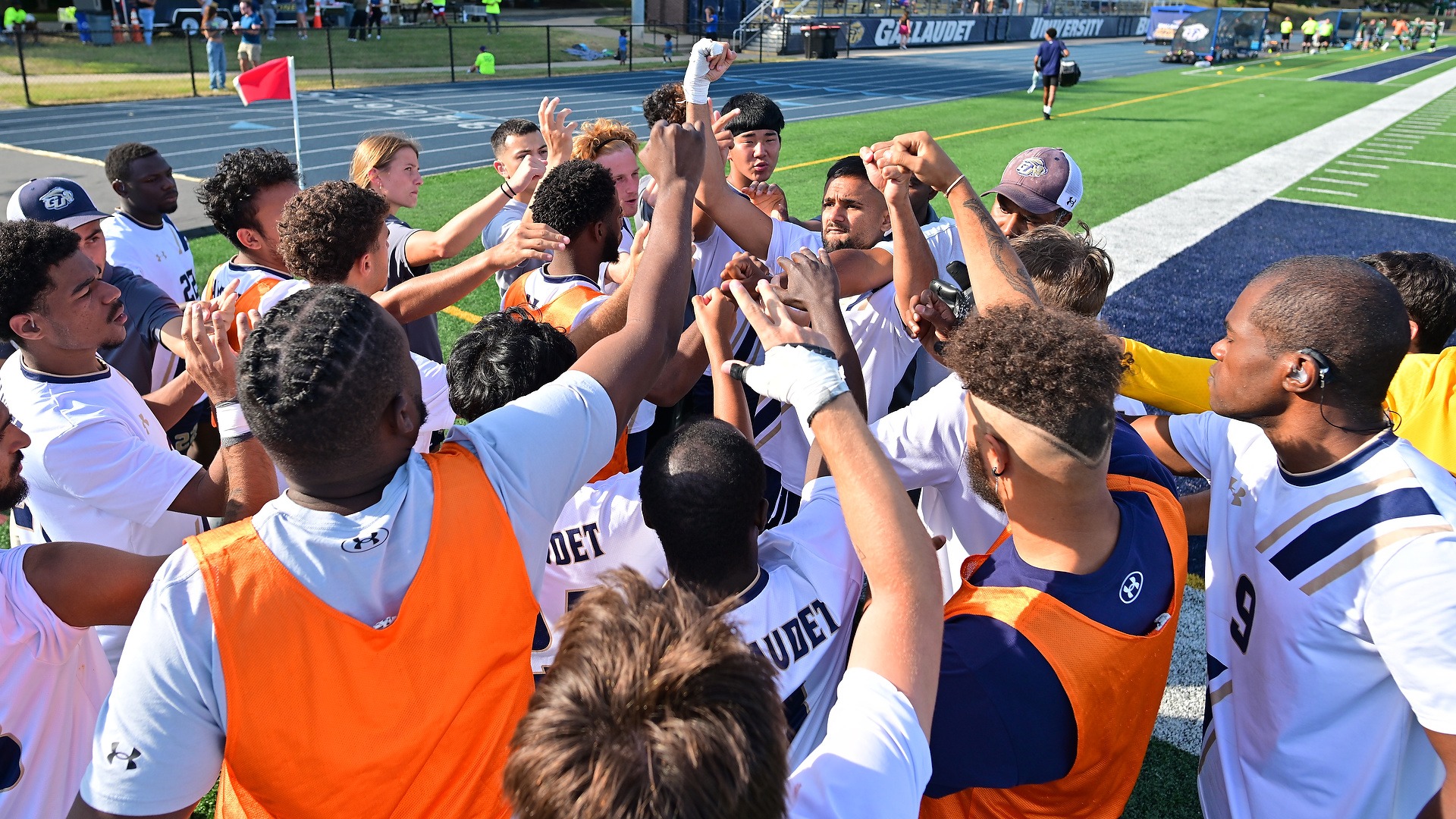 Gallaudet's men's soccer team gathered before game at Tristan Torbett kick off classic to doing high five together