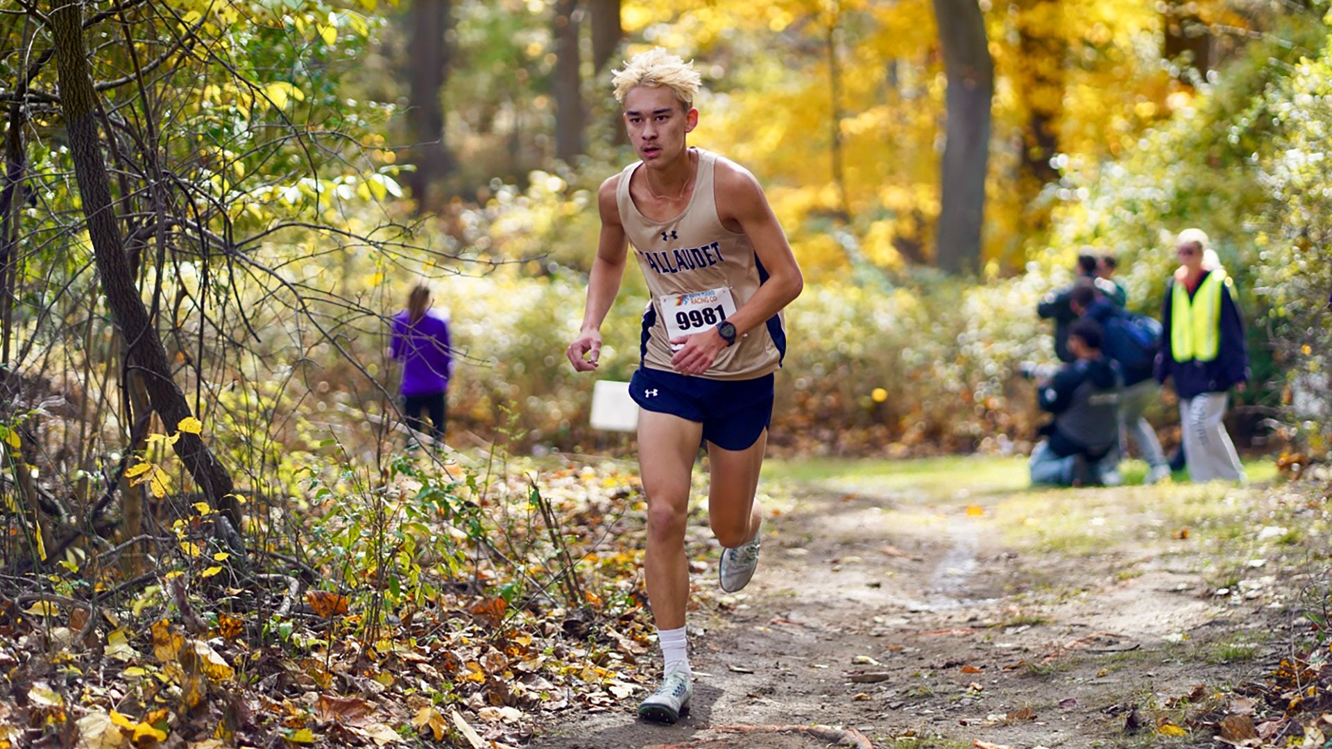 Gallaudet men's cross country runner Sevan Ikeda runs up a hill at the 2025 United East Conference Championship meet on a sunny morning. 