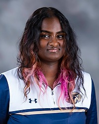 2025-26 Gallaudet University women's basketball team manager Anvita Corron headshot photo. she is wearing a white and navy blue pullover against a grey background.