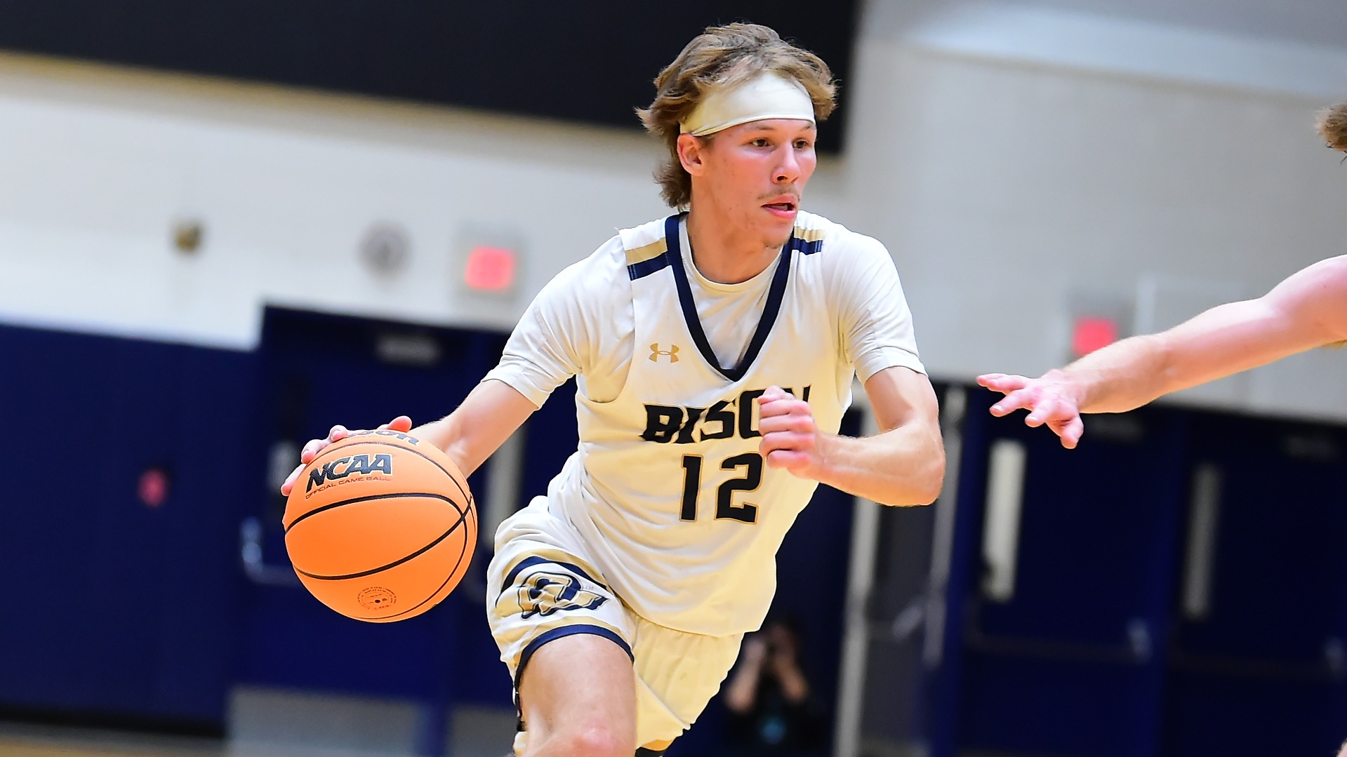 Gallaudet men's basketball player Alex Ortman dribbles the orange basketball and drives towards a lane during a home basketball game during the 2025-26 season.