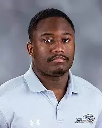 Gallaudet University men's basketball team manager Joshua Bourne headshot photo. He is wearing a grey polo shirt against a grey background.