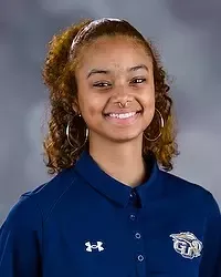 Gallaudet University men's basketball team manager Melika Washington headshot photo. she is wearing a navy blue polo shirt against a grey background.