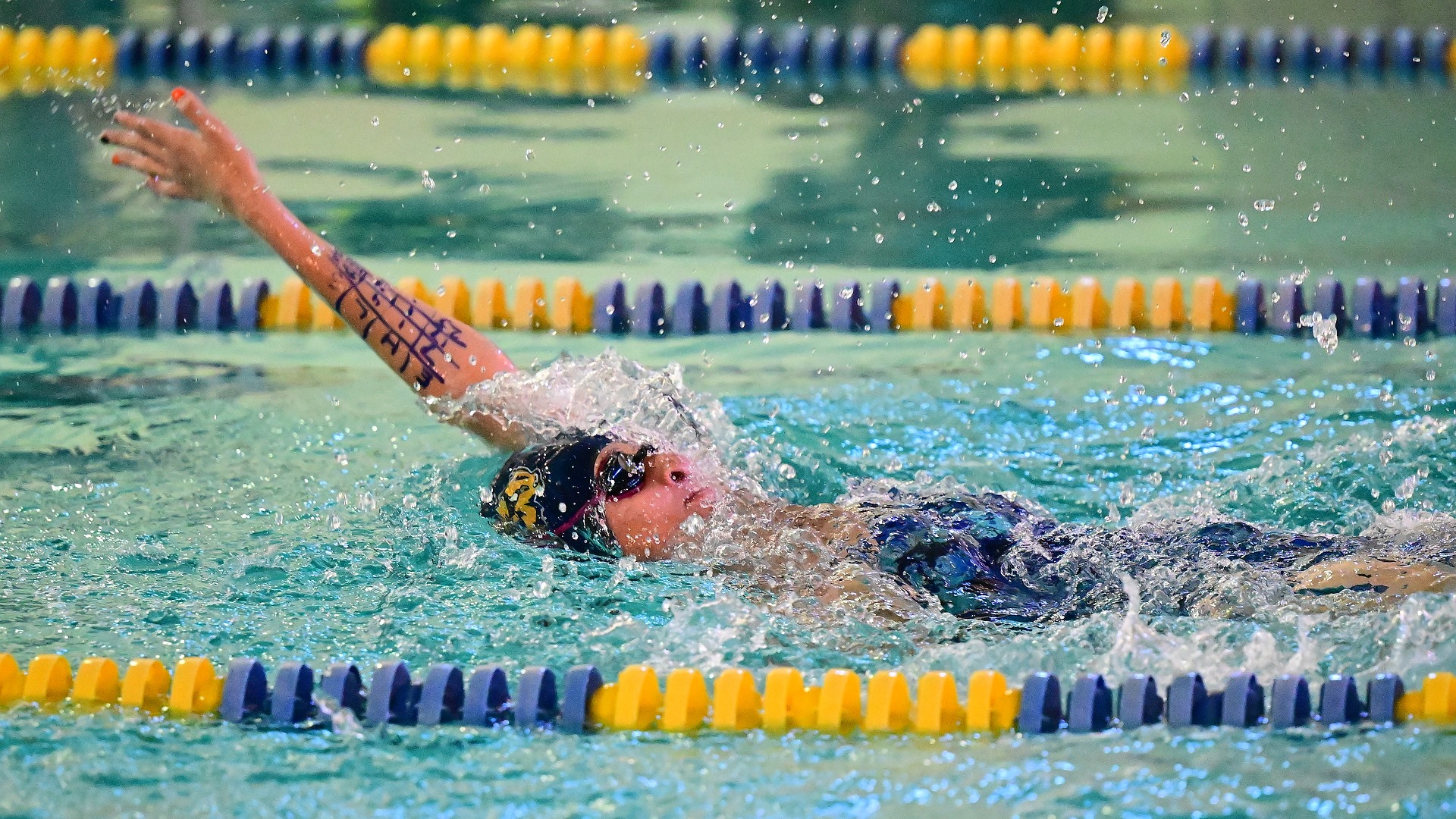 Gallaudet women's swimmer Adelle Patton swims the backstroke in the pool during a home meet.