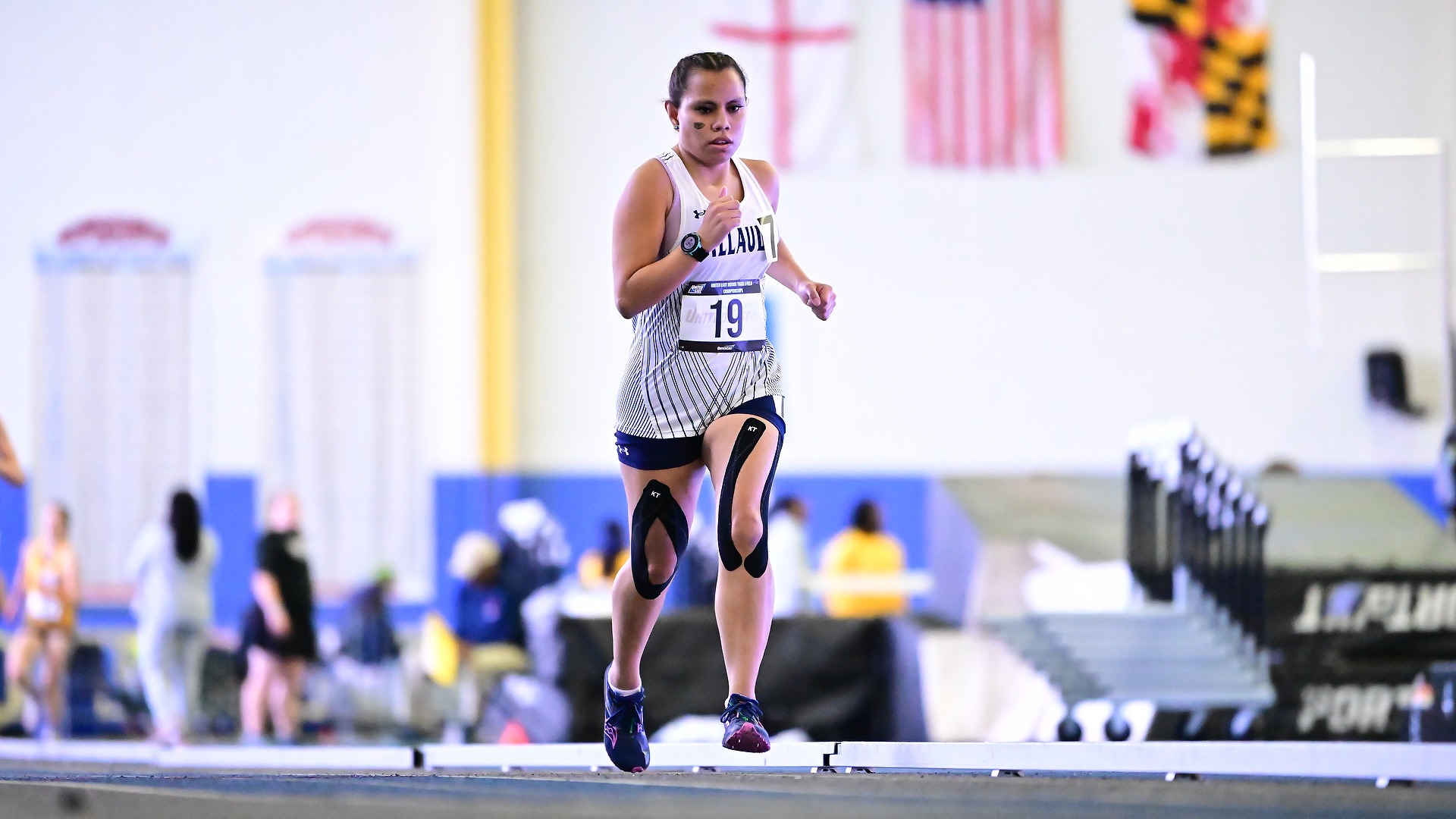 Gallaudet women's indoor runner Olivia Armstrong runs in an indoor race.