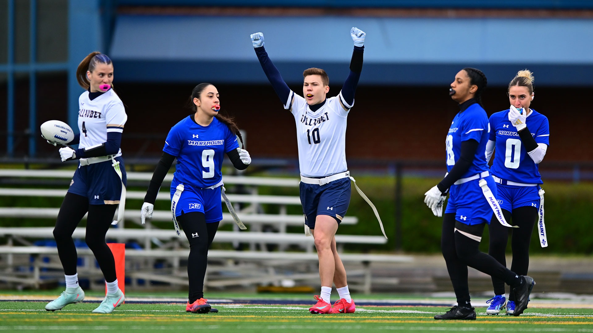Gallaudet women's flag football player Raj Guettler (middle) and Cam Lexow (far left) celebrate an extra-point score for the Bison against Marymount University Saints on Saturday at home.