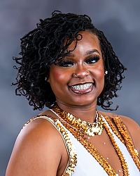 Motion Z headshot photo of Chelsea Sampson, who is smiling and looking towards the camera. A gray background is behind Sampson.