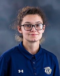 Softball headshot photo of Bekah Burr , who is looking towards the camera. A gray background is behind Burr.