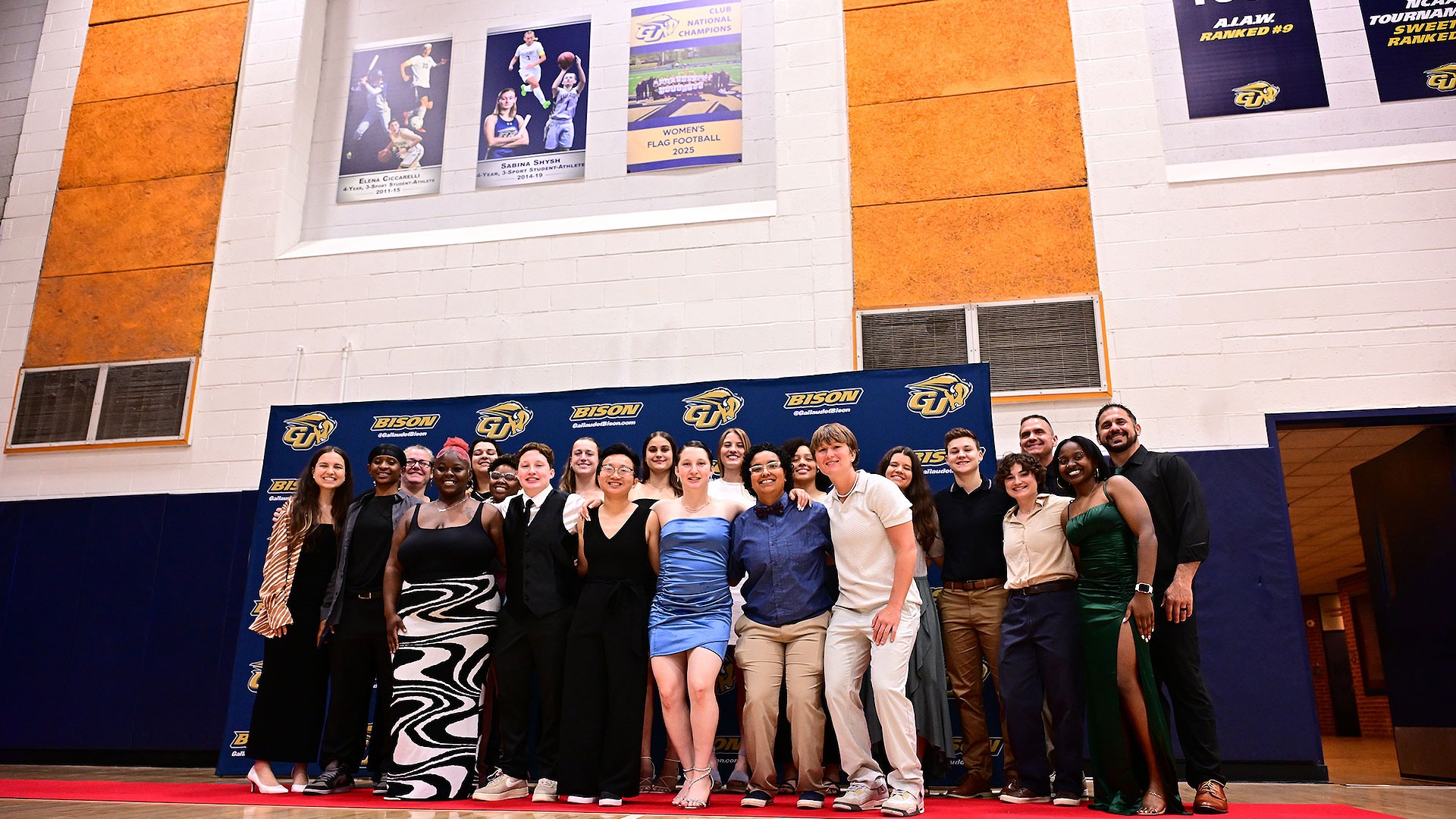 Gallaudet women's flag football team pose for a group photo in front of their club championship banner for 2025.