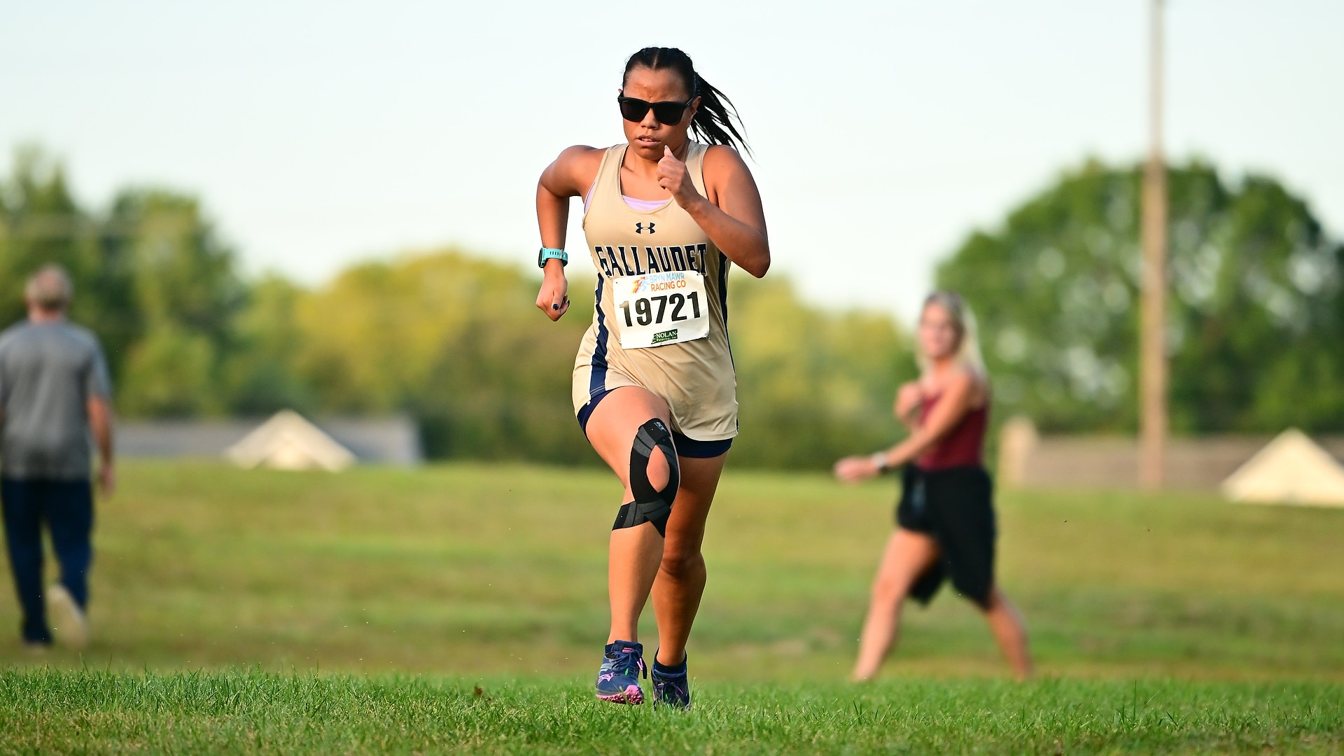 Gallaudet women's cross country runner Olivia Armstrong finishes a race strong as she runs towards the finish line.