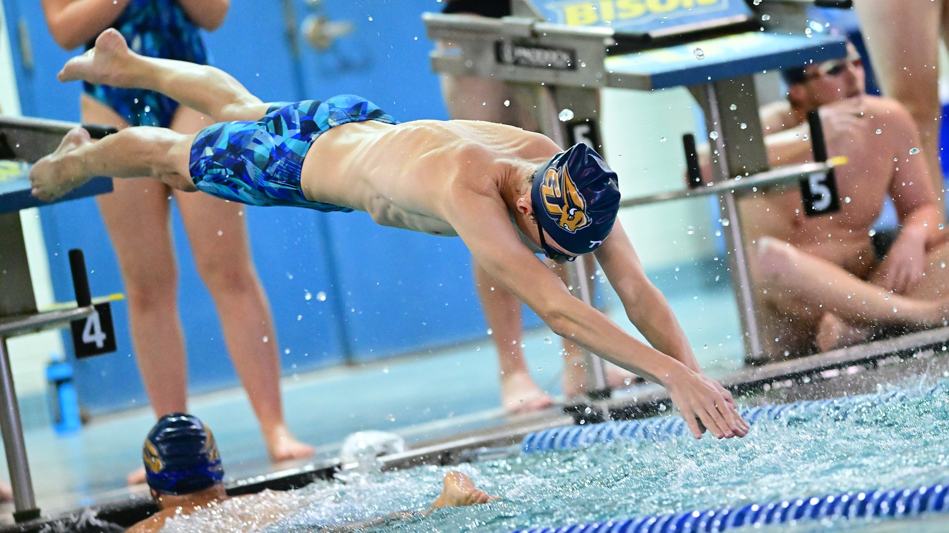Gallaudet University men's swimmer Alex Wilding dives into the Field House pool during a relay event.