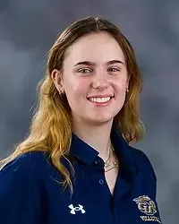 Nicole Hicks - 2026 Gallaudet men’s volleyball headshot. The Bison student-assistant coach wears a navy colored polo and looks towards the camera. A gray backdrop is in the background.