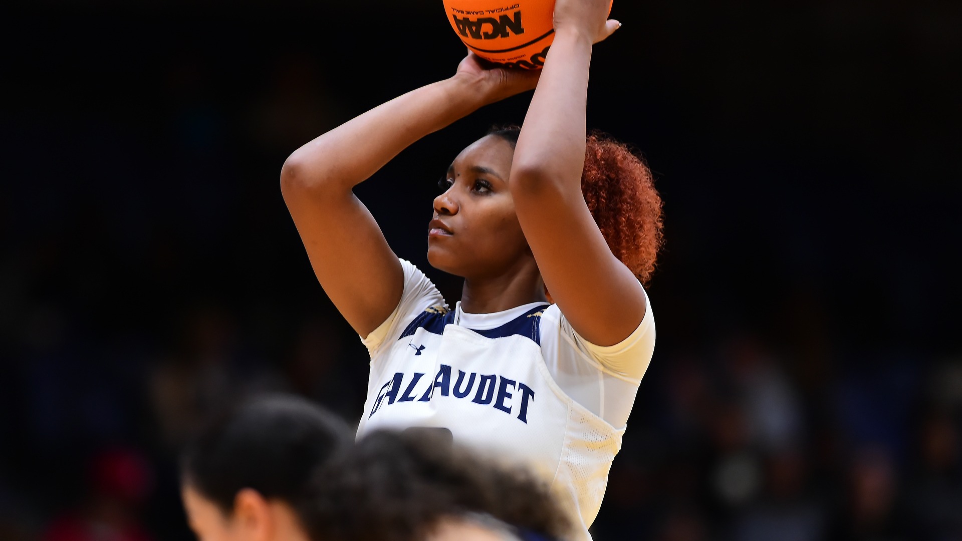 Gallaudet women's basketball player Natalie Greene is attemping to shoot the ball from the free throw line during a home game in the Field House against Washington Adventist University.