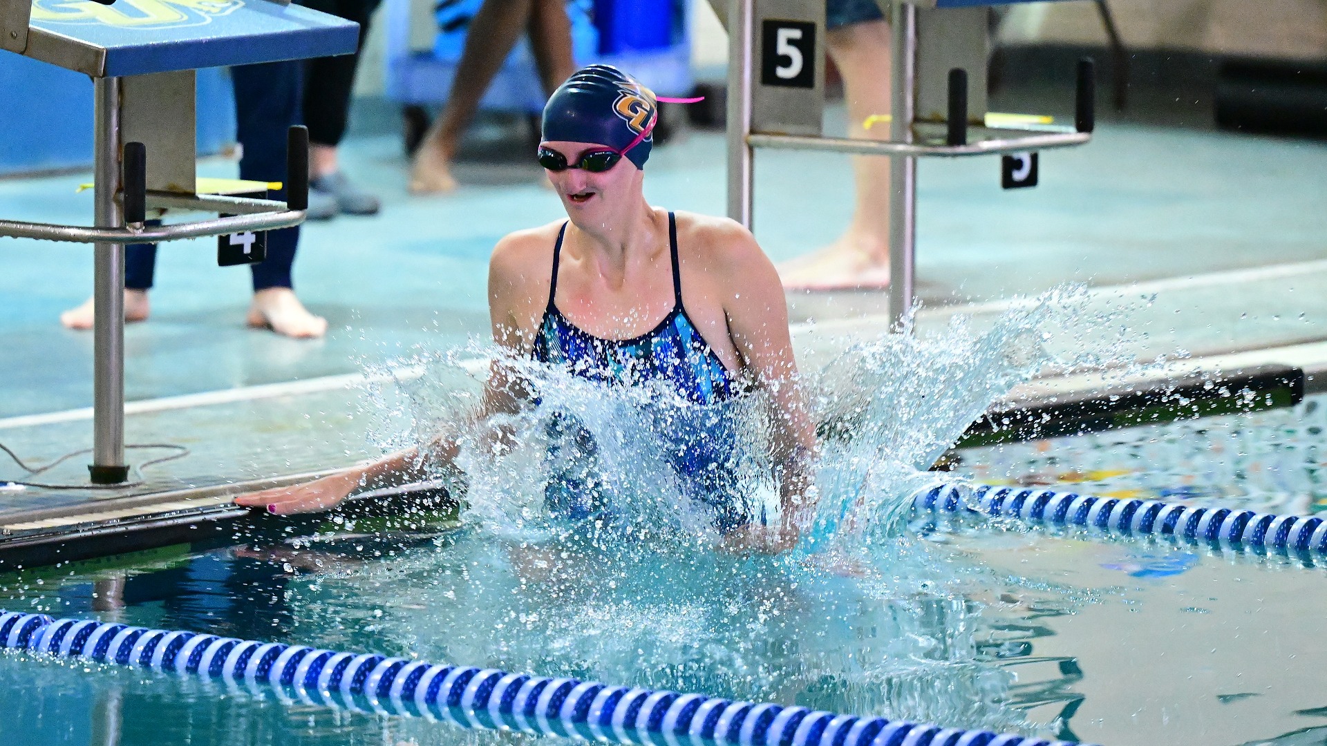 Gallaudet women's swimmer Adelle Patton leaps out of the water to celebrate a new personal record time in an event after the race was over. 