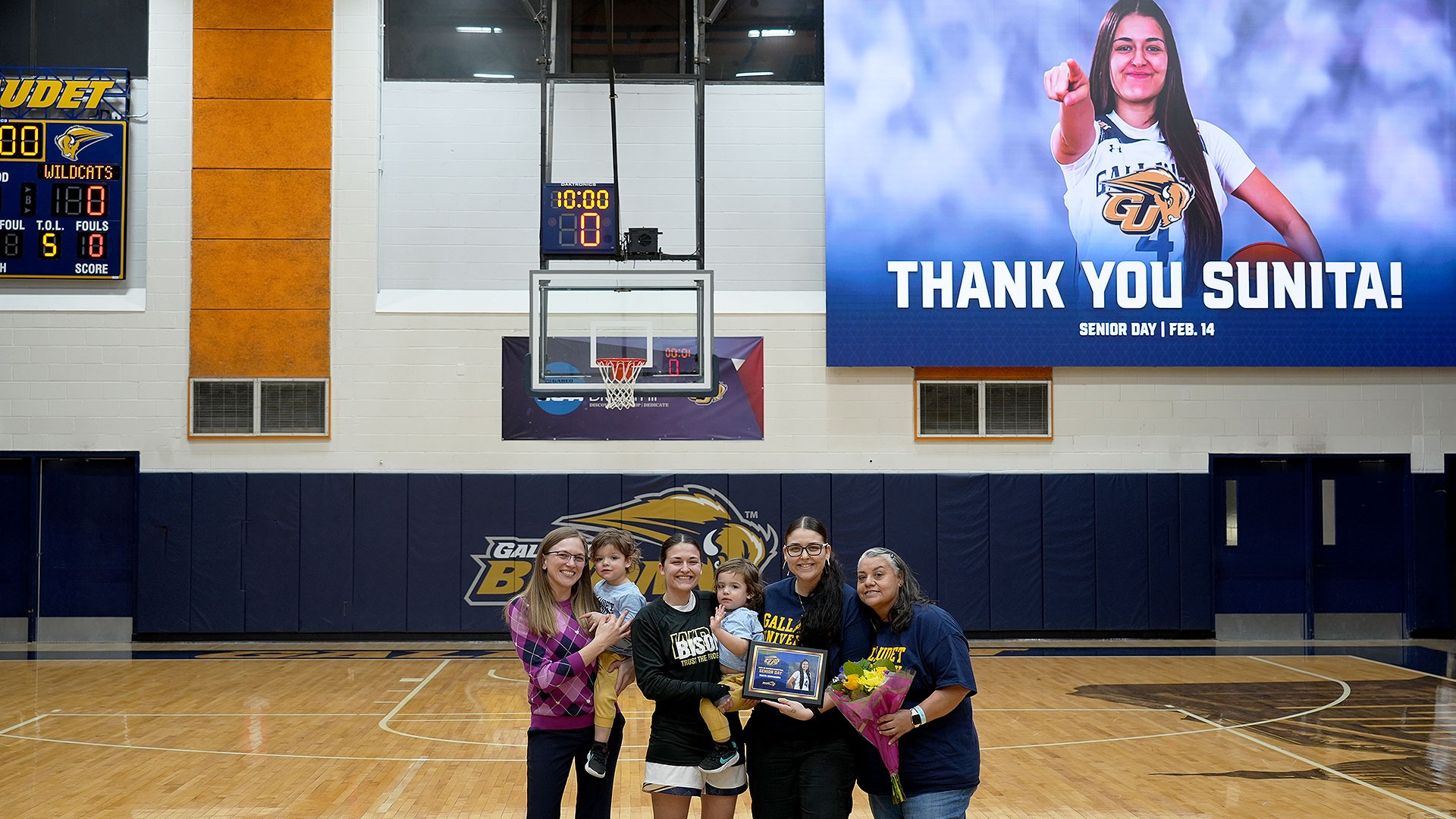 Gallaudet women's basketball graduating senior Sunita Schmidjorg is celebrated before the start of the Bison game on Senior Day. Sunita is pictured with her children, Aunt and Sister along with Bison head coach Stephanie Stevens.