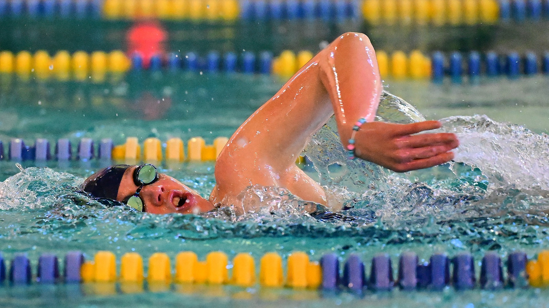 Gallaudet women's swimmer Hope MacPeek swims the freestyle during a home meet in the Field House pool.