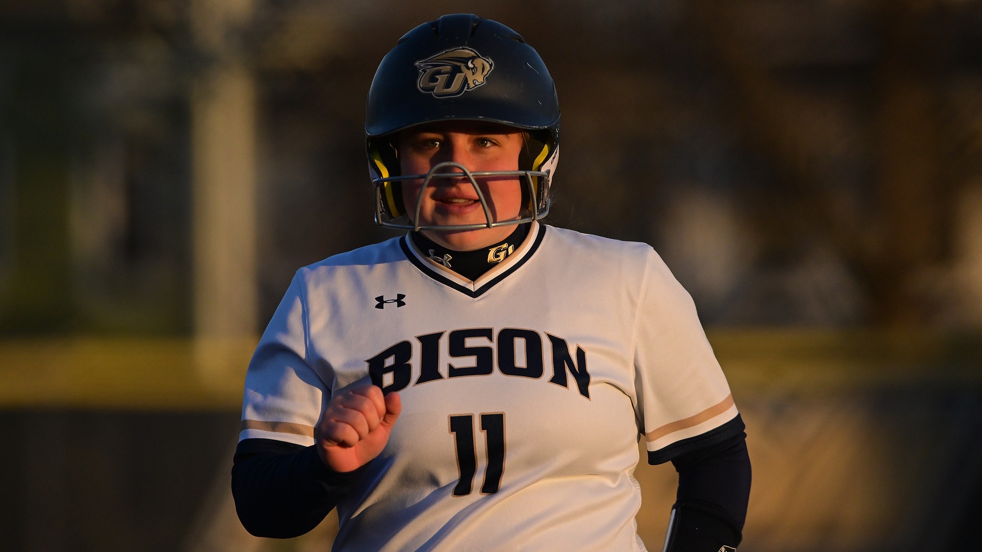 Gallaudet softball player Kinsley Bond is smiling after batting during an afternoon game.