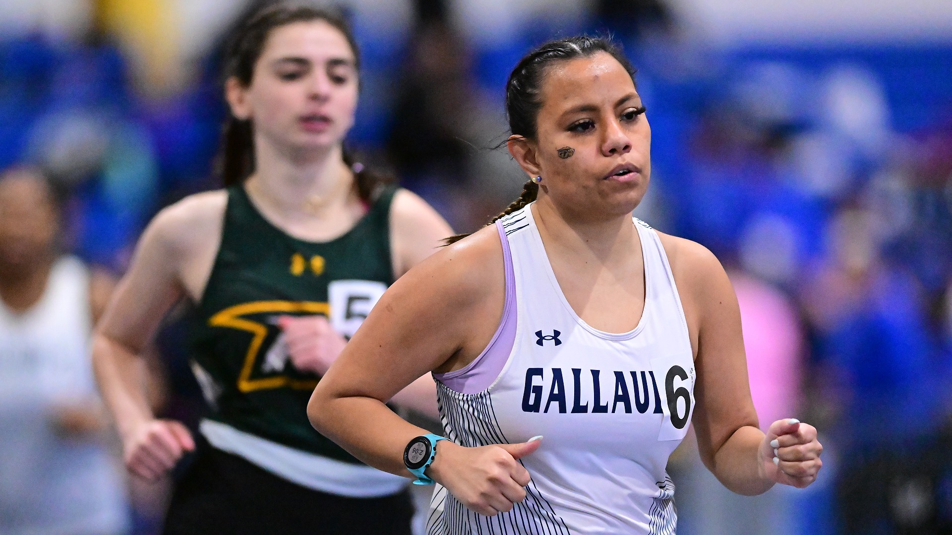 Gallaudet women's indoor track and field runner Olivia Armstrong runs in a meet in Landover, Md., and is leading against a runner from McDaniel College behind her. 