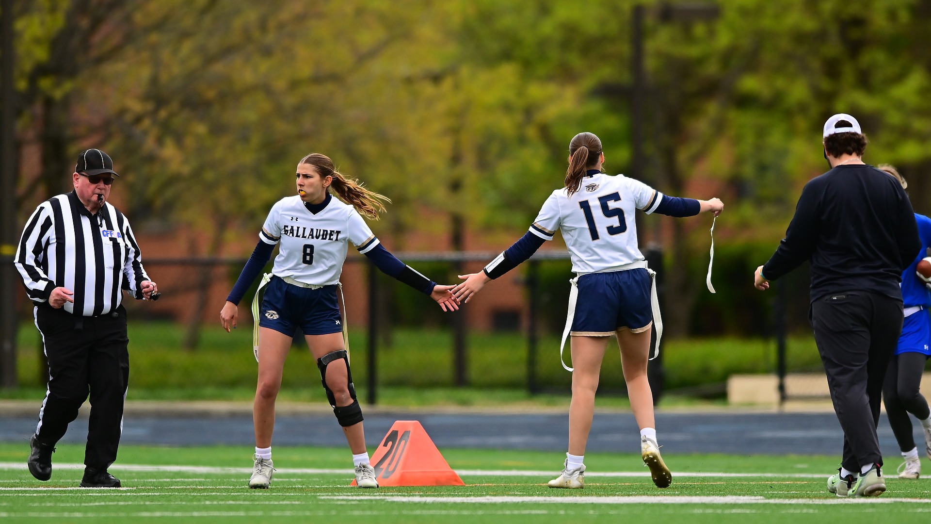 Gallaudet women's flag football players Gianna Visco and Citrine Lummer exchange high fives after a big play in a home game at Hotchkiss Field.