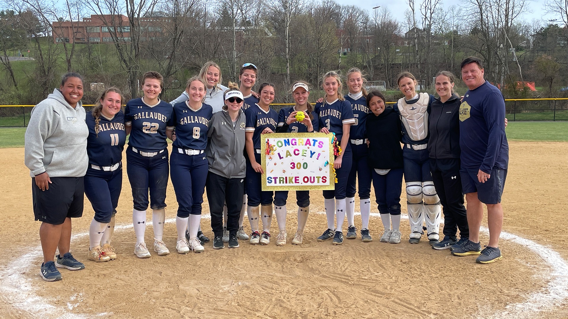A group picture of Lacey Drolsbaugh's 300th career strikeouts ball with her teammates and coaches at Penn State Scranton softball field