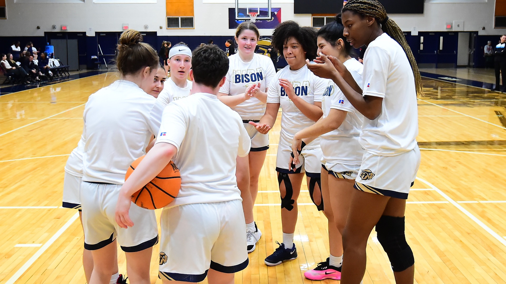 Gallaudet women's basketball team players huddle up during the pregame of a home game during the 2025-26 season.