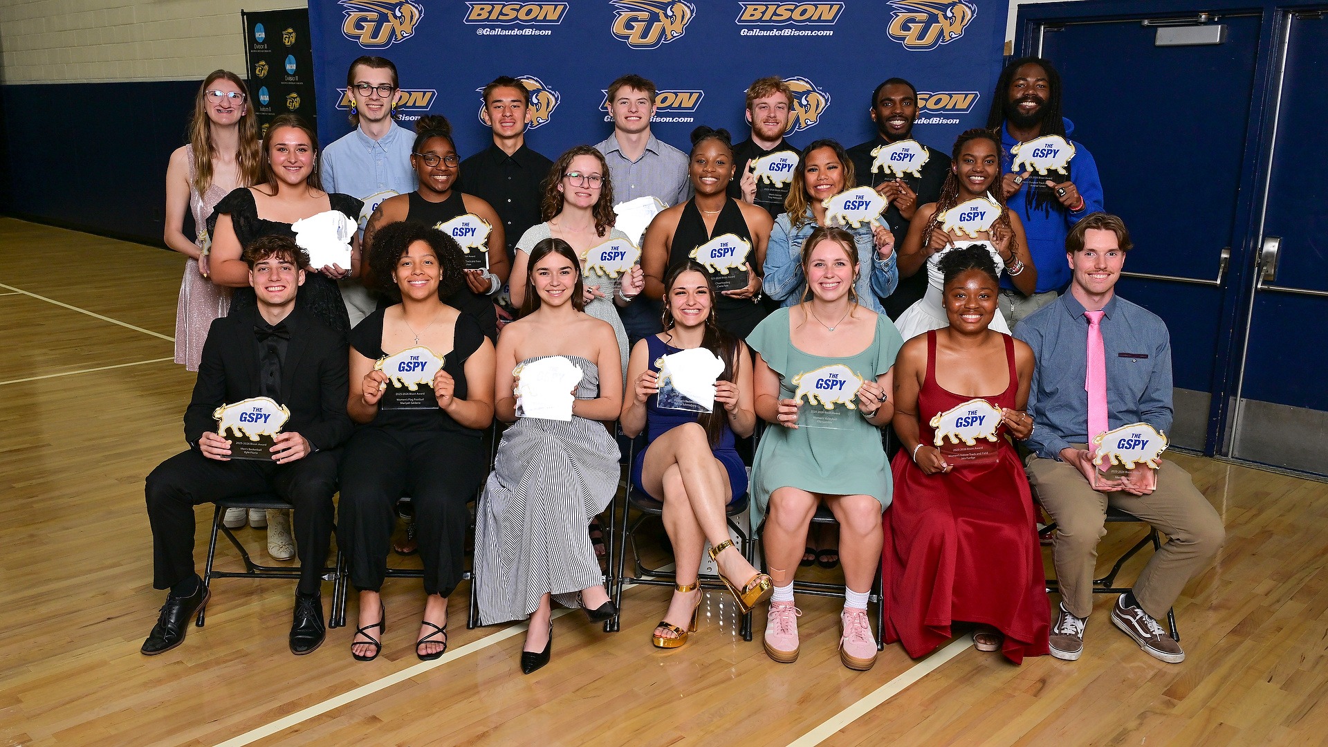 Gallaudet student athletes who earned the BISON Award are seated and grouped together for a large group photo during the 2026 GSPYs award ceremony in the Field House gym. 