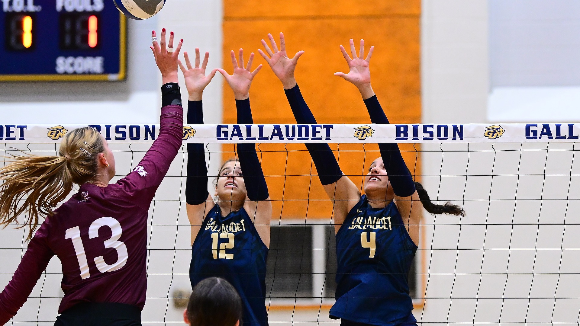 Gallaudet women’s volleyball players Gracie Gloster (#12) and Bri Eilderts (#4) leap together for a block against an Eastern University attacker during Saturday’s match in the Field House.