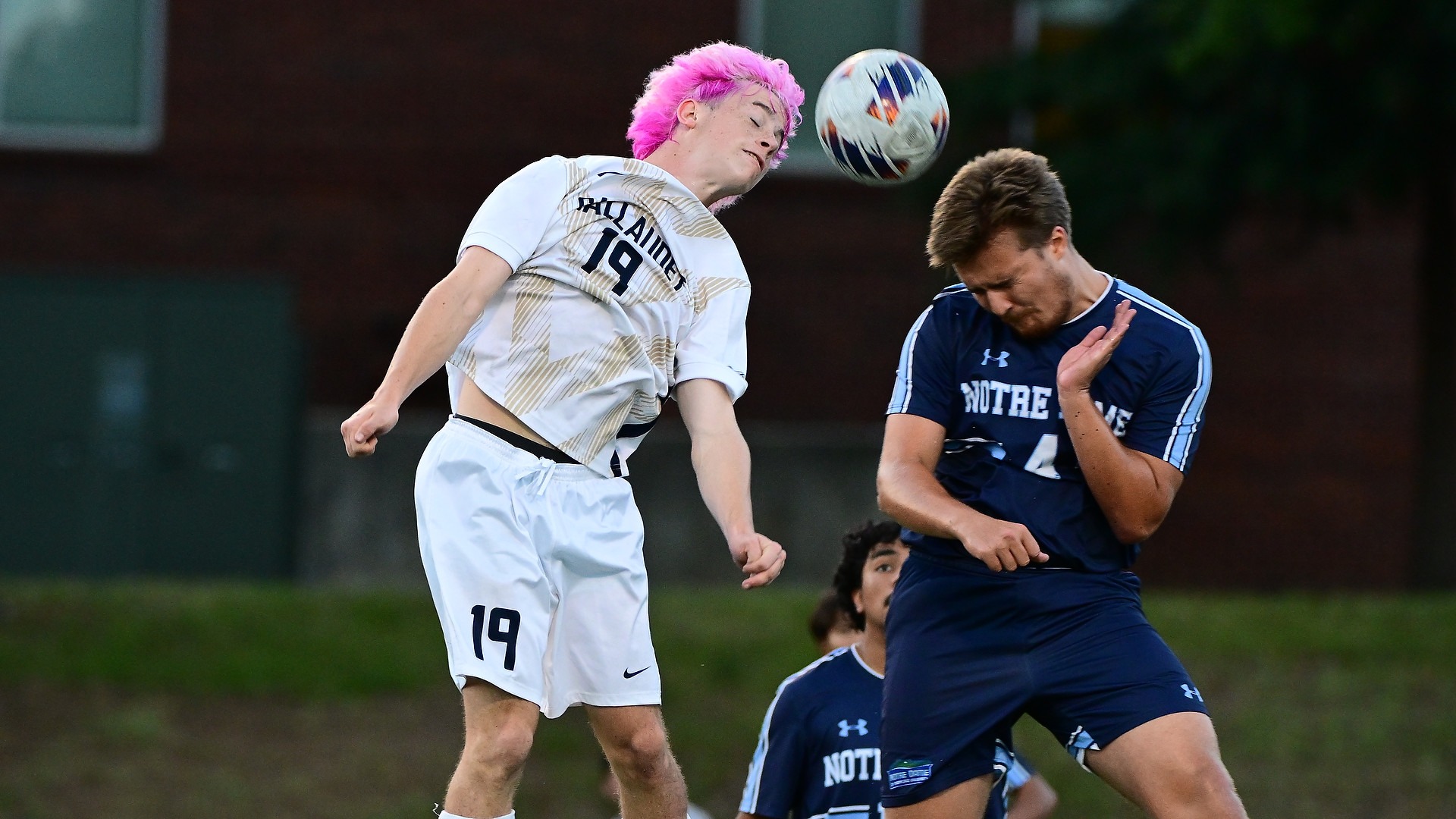 Gallaudet first-year midfielder Eli Matamoros (#19) heads the ball while battling Notre Dame of Maryland University defender Martin Rasiwala (#4) during a men's soccer game at Hotchkiss Field.