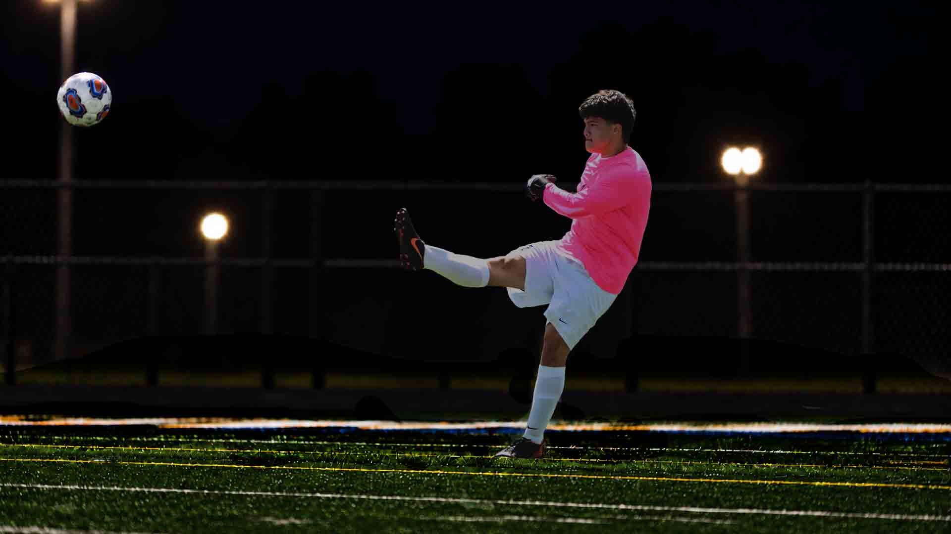 Gallaudet University goalkeeper Donovan Schneck kicks a ball during a night game for the Bison.