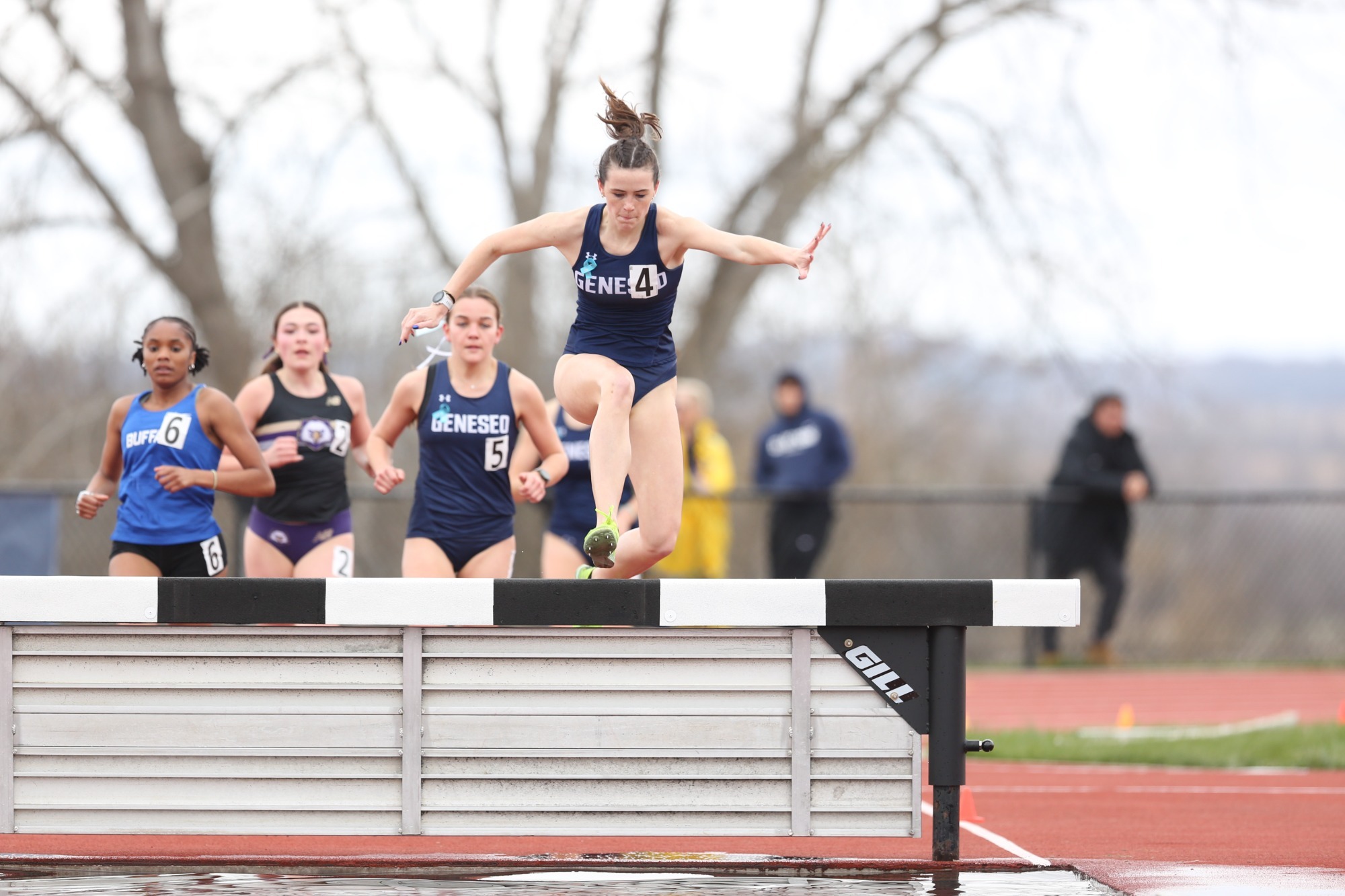 Geneseo track athlete jumping over the steeple at their home invite