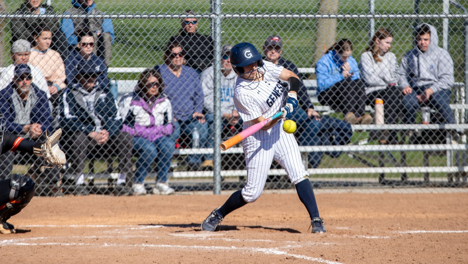 Softball batter hitting a pitch