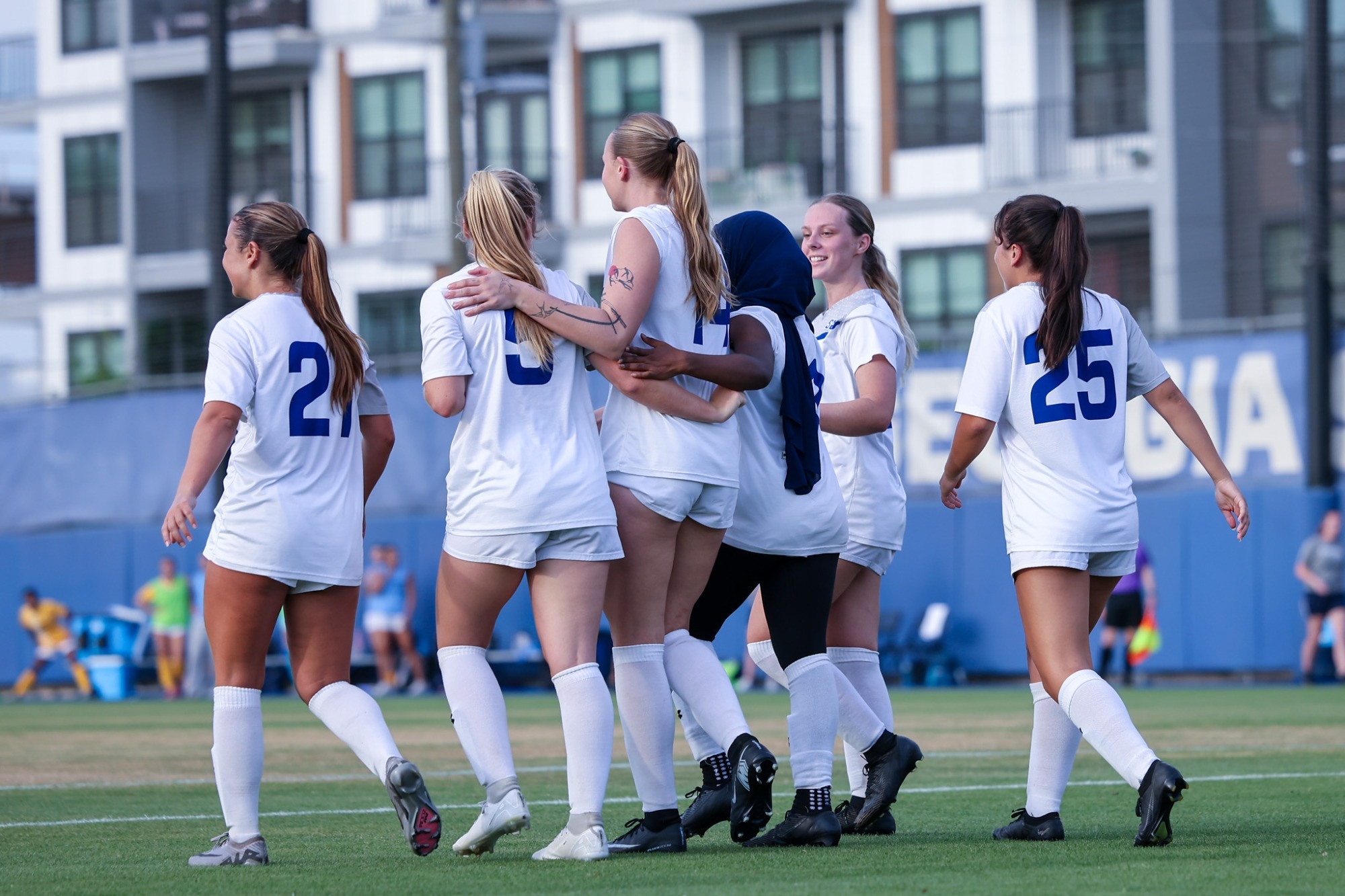 Women's soccer team walks onto field.