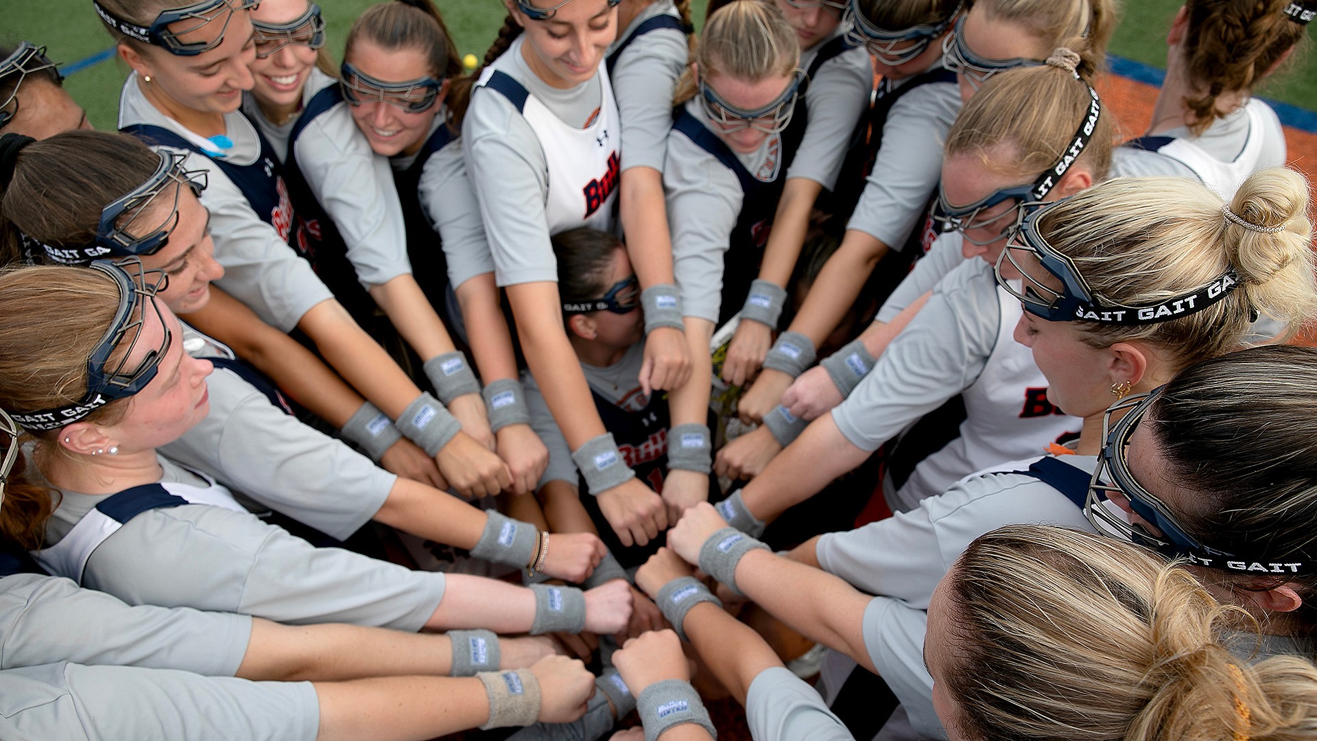 Women's Lacrosse players display their wrist bands embroidered with Sadie Mauro’s initials
