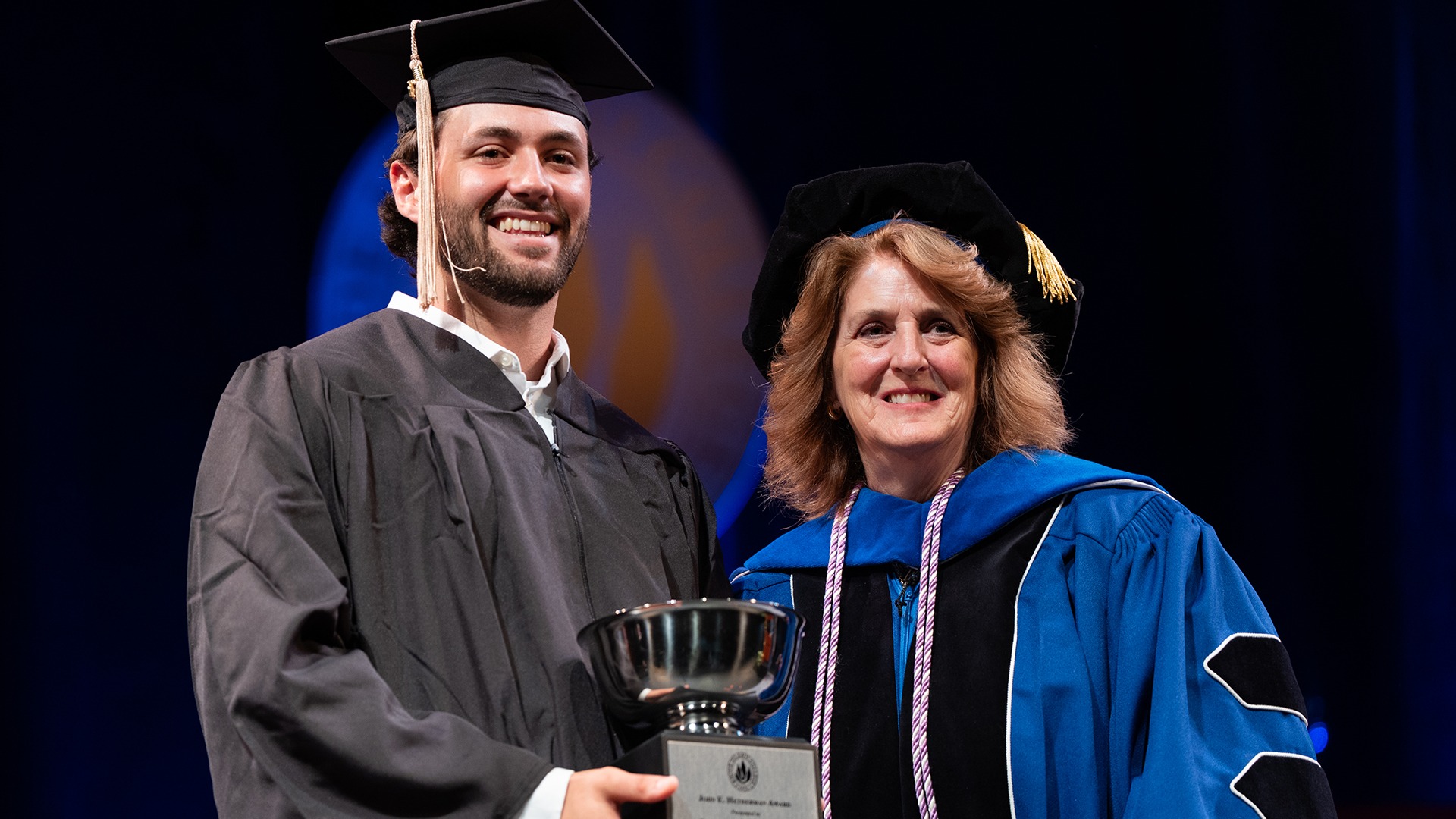 Lucas Duquette receives the John E. Hetherman Award from Nan Griffin at Cap and Gown Day