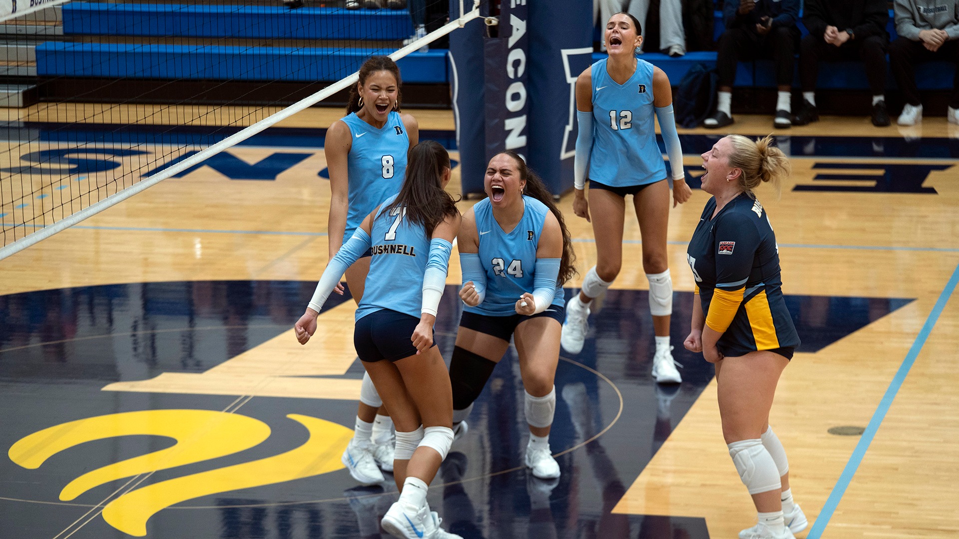 Bushnell Volleyball Players celebrate after beating Corban University.
