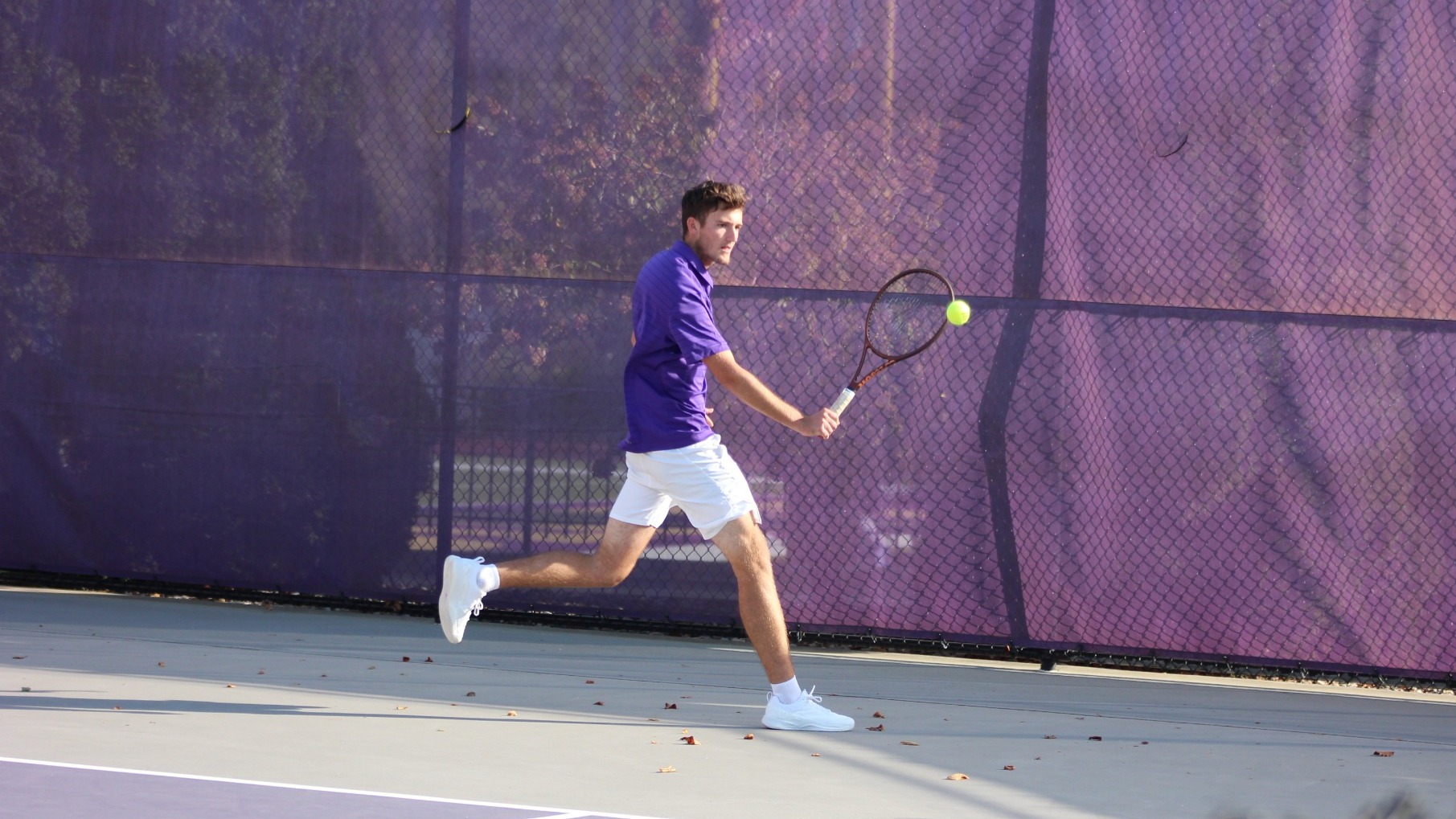 Men's Tennis plays a back hand
