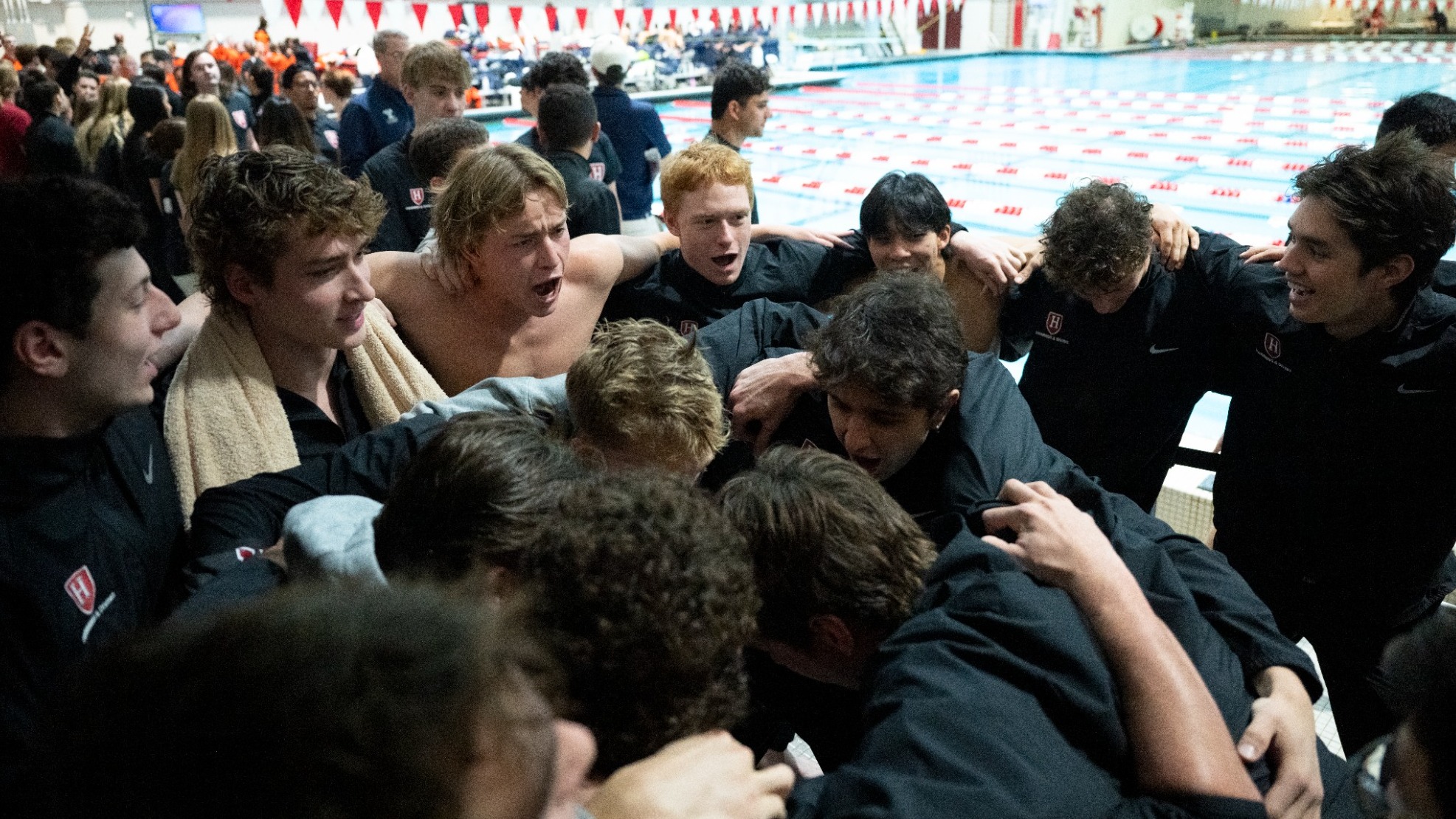 Men's Swimming and Diving in a huddle at Blodgett Pool