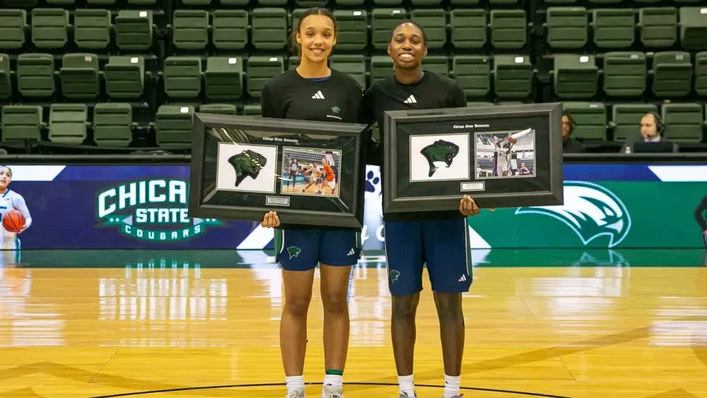 Women's Basketball senior holding their senior plaques center court 