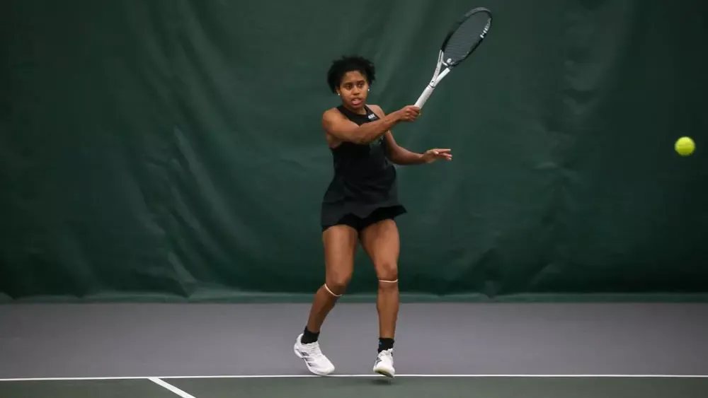 Women's Tennis Student Athlete Danina Hughes hitting a tennis ball 