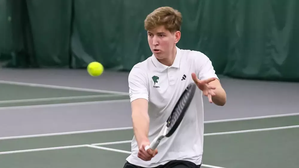 Tennis Student Athlete Yurii Hoida hitting a tennis ball 